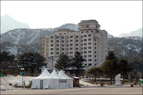 온정각 옆의 김정숙 휴양소. ‘금강산을 근로자들의 문화휴양지로 꾸리자’는 취지로 만들어진 북한의 휴양시설이었으나, 수리 후 남한 관광객을 위해 사용할 것이라고 합니다. 앞의 천막은 북한이 운영하는 포장마차 ‘온정봉사소’. 오른쪽 아래는 김정일 국방위원장 방문 기념비. 